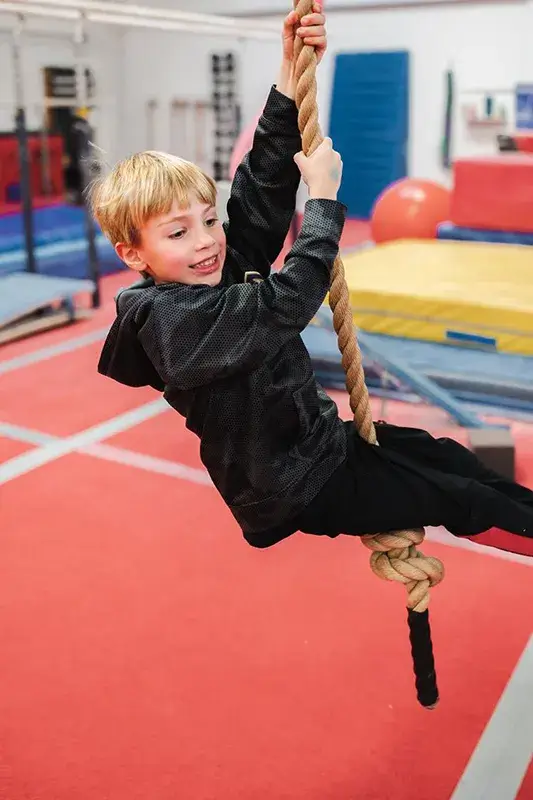 a boy climbing a rope