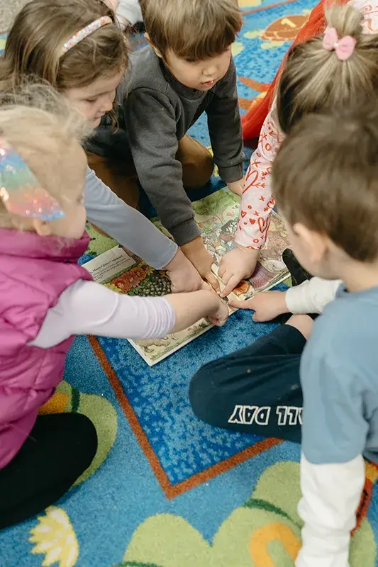 kids pointing at a book